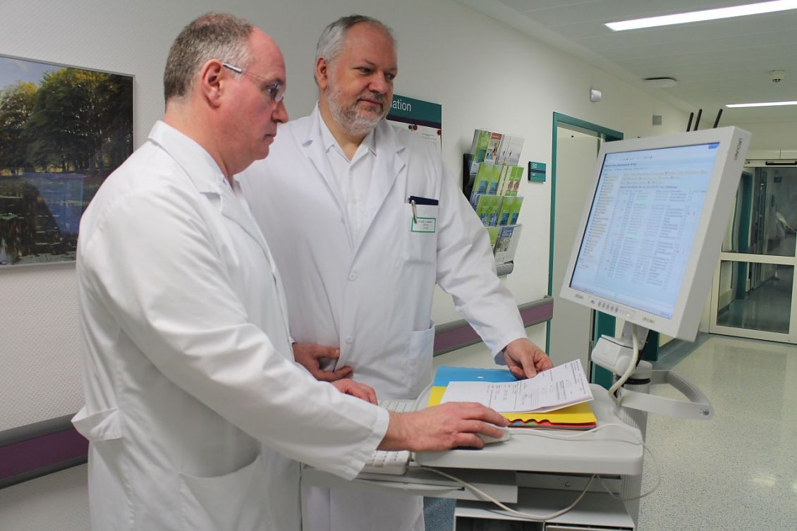 Das Foto zeigt Dr. Joachim Alefelder (rechts) am Visitewagen mit Dr. Matthias Beintker (Foto: S&uuml;dharz Klinikum)